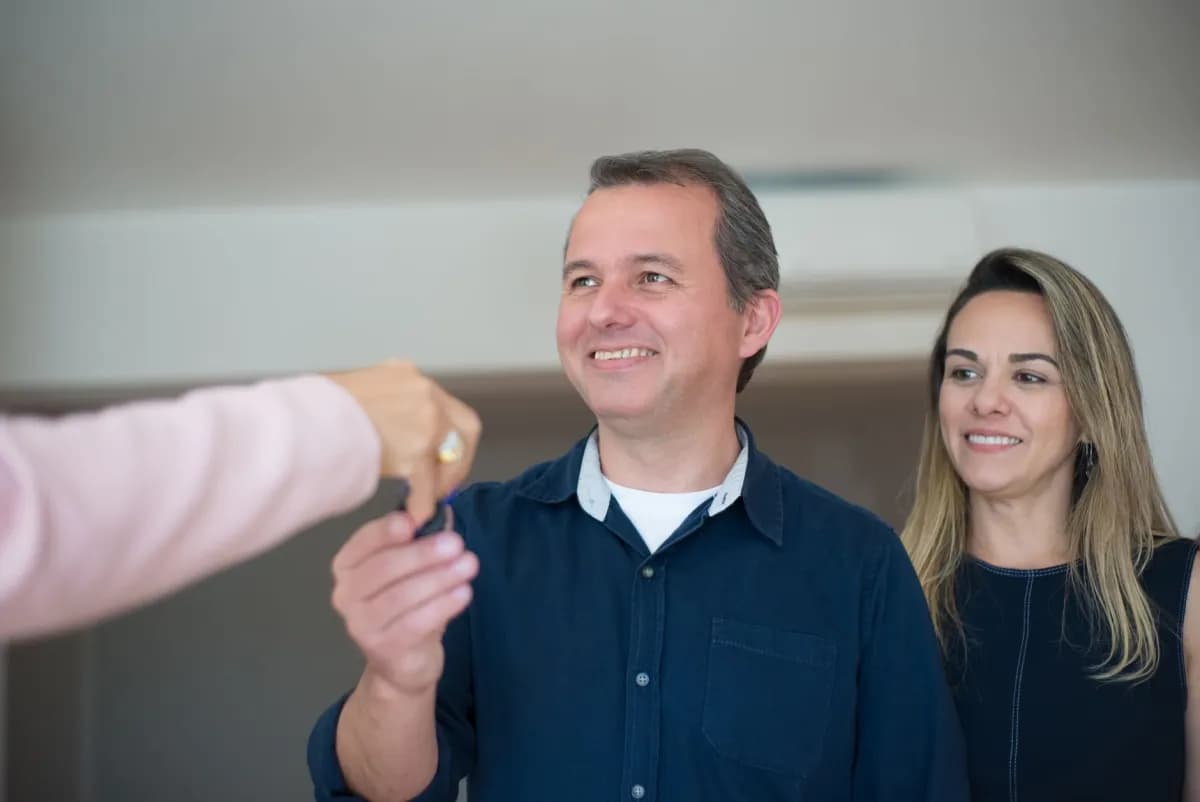 Couple récupérant les clés de son nouveau logement acheté grâce à un prêt relais